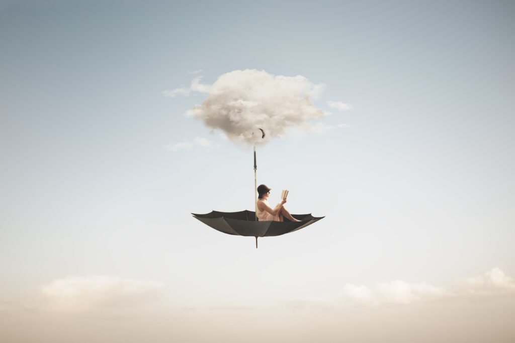 Frau liest Buch, fliegt auf einem umgedrehten Regenschirm durch die Wolken.